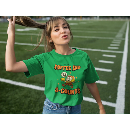 Cheerleading coach wearing a green t-shirt with a cheerleading graphic design on a football field