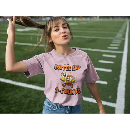 Cheerleading coach wearing a pink t-shirt with a cheerleading graphic design on a football field