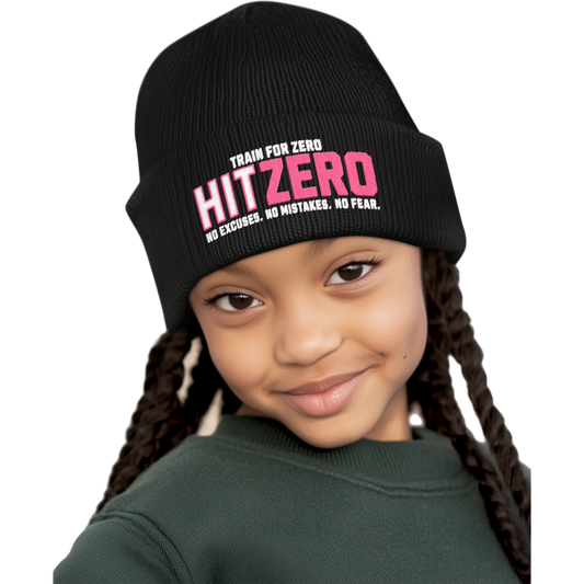 Child wearing a black beanie with 'HIT ZERO' text on a beige background
