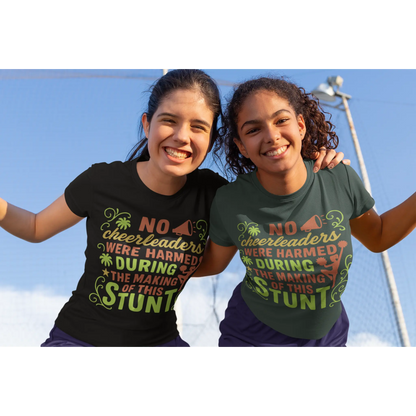 Two girls wearing t-shirts with a humorous message about cheerleaders, standing outdoors against a clear blue sky.